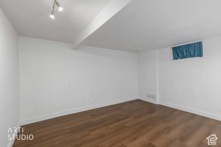 Wood-finish flooring, white walls, white trim, recessed lighting, and a single window