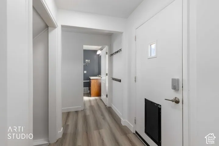 Wood-finish flooring with white baseboards and trim