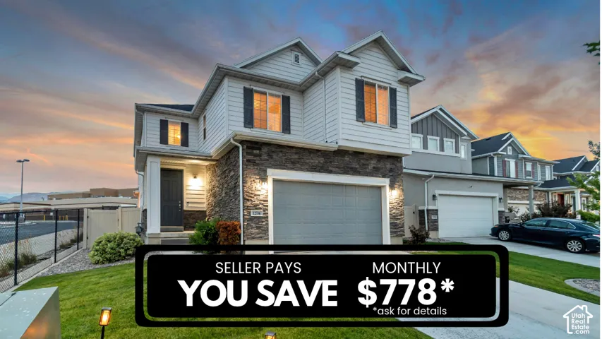 Two-story exterior featuring horizontal siding, stone veneer accents, an attached garage, and a concrete driveway