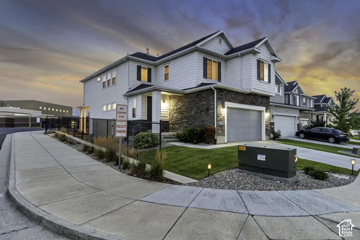 Two-story residence featuring light siding and stone veneer accents