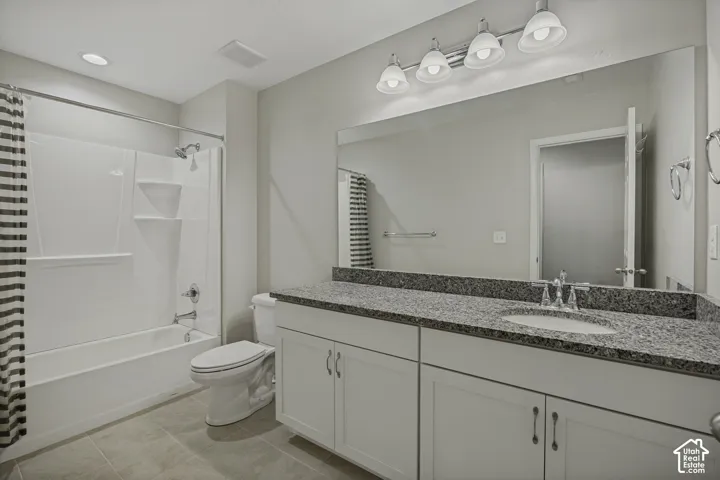 White vanity with integrated sink, speckled countertop, and chrome fixtures