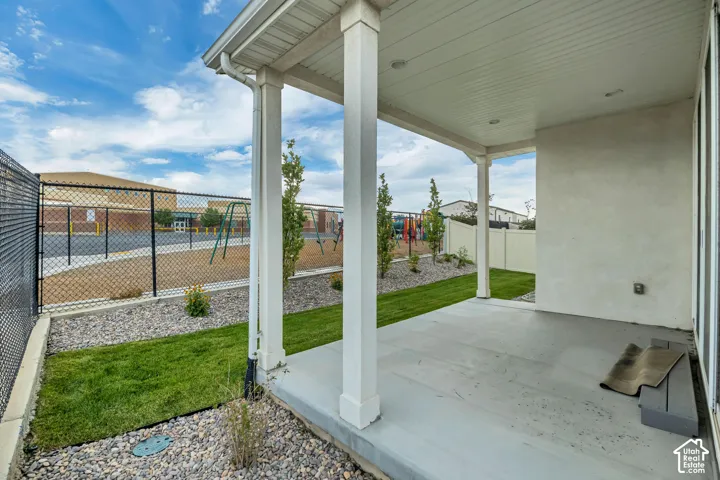 Covered patio with recessed lighting, concrete flooring, and white support columns