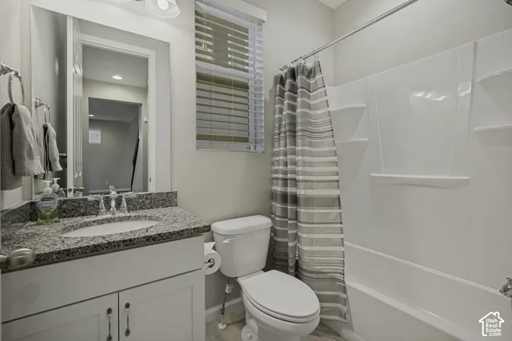 Bathroom featuring a vanity with a granite-style countertop, a white sink basin, and a chrome faucet