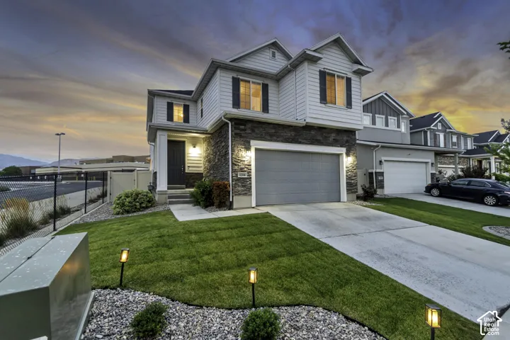 Two-story exterior with light gray siding and dark stone facade