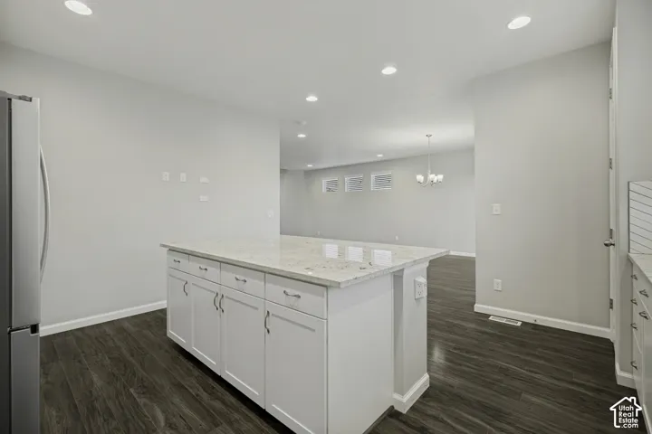 Kitchen island with white cabinetry and light-toned countertop