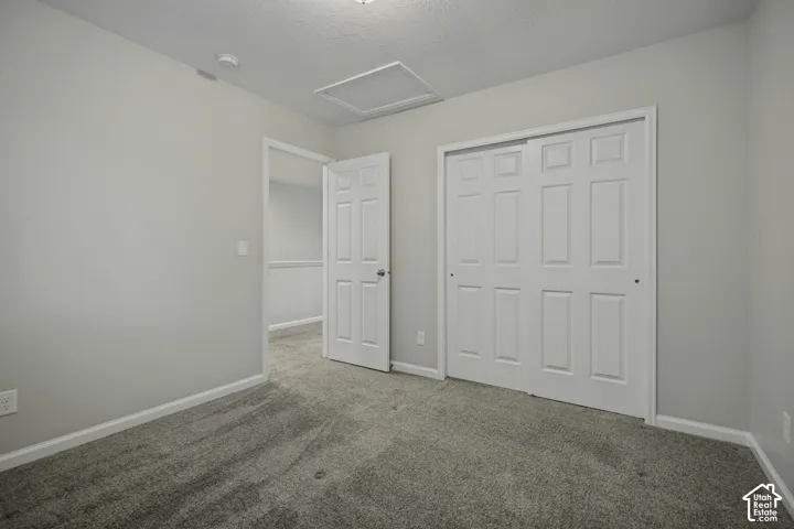 Neutral wall color, plush carpeting, white trim, paneled doors, and a ceiling access panel