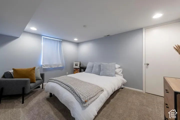 Recessed lighting, light-toned walls, carpeted flooring, and a white door