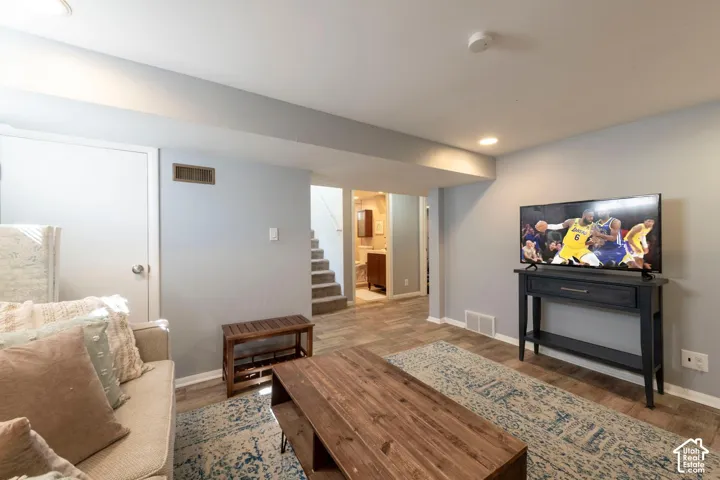 Recessed lighting illuminates the space, featuring wood-finish flooring and light gray walls