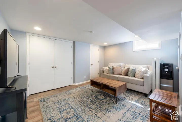 Recessed lighting, wood-finish flooring, white double doors, and a window well
