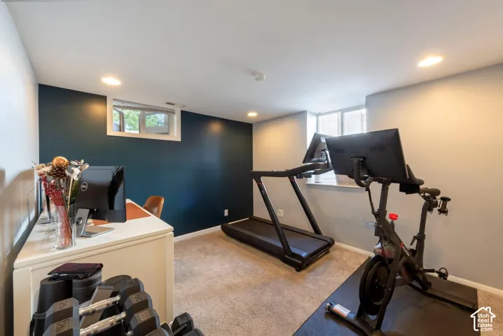 Recessed lighting illuminates the space, featuring carpeting and varied wall finishes