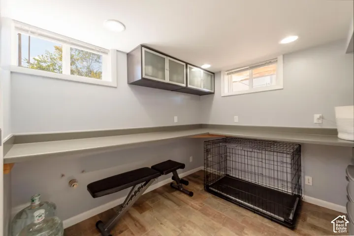 Wood-finish flooring, recessed lighting, built-in cabinetry, and a continuous built-in countertop