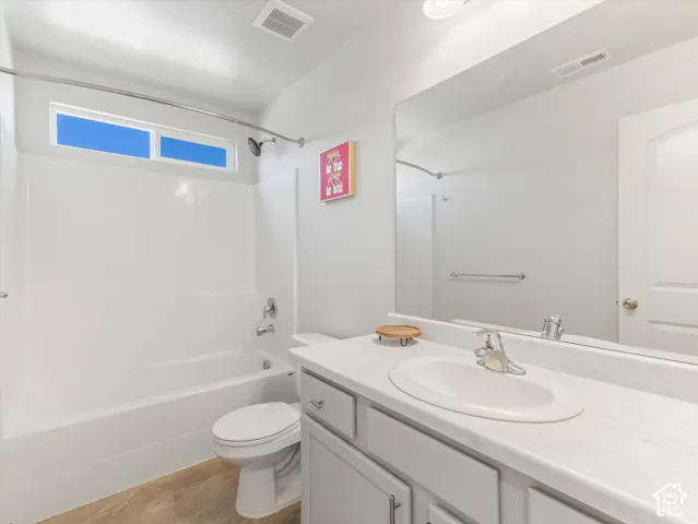 White vanity with an integrated sink, polished chrome faucet, and gray cabinetry