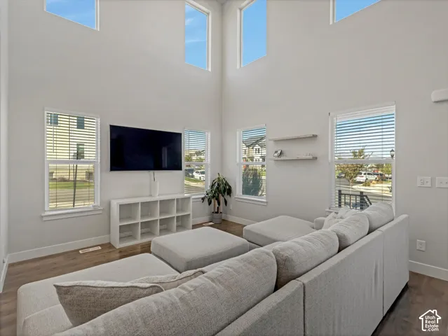 Two-story height ceilings with high windows, wood-finish flooring, and multiple windows