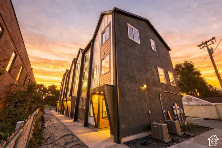 Modern multi-unit property featuring a dark stucco exterior with light wood-tone and white siding accents