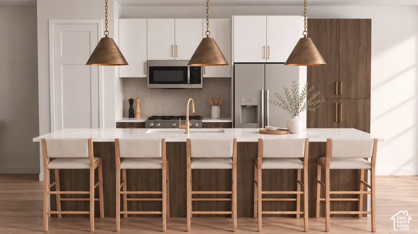Kitchen featuring a large island with seating, stainless steel appliances, white upper cabinetry, wood-finish lower cabinetry, and pendant lighting