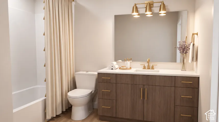 Bathroom featuring a white bathtub, wood-finish vanity with gold hardware, integrated rectangular sink, gold-finish faucet, and a wall-mounted rectangular mirror with a gold-finish light fixture