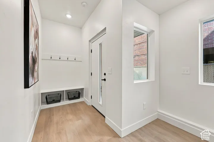 Entryway featuring wood-finish flooring, built-in storage bench, and recessed lighting