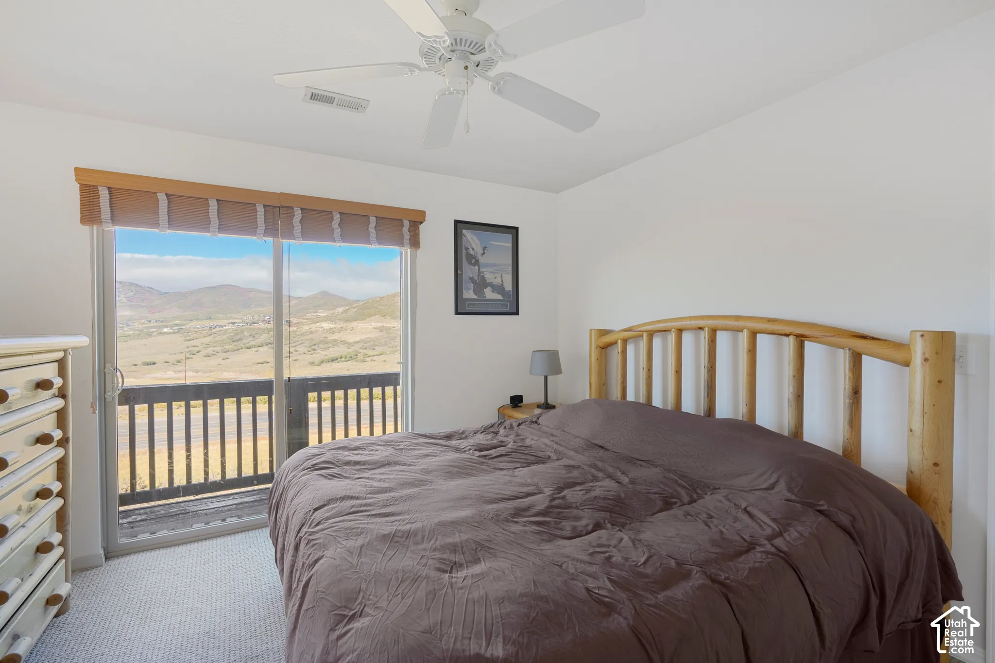 Sliding glass door opening to an exterior balcony with mountain scenery