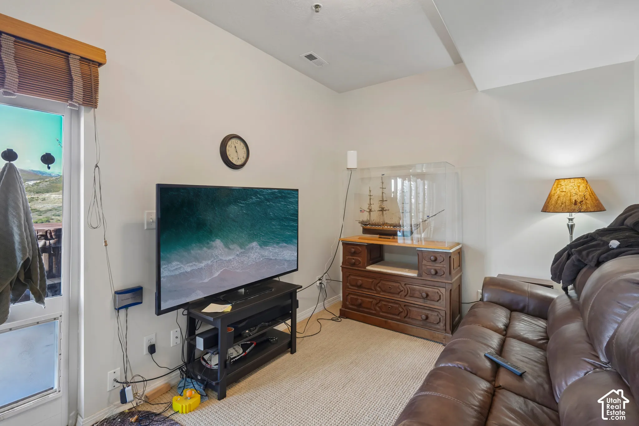 Sloped ceiling with recessed lighting, light-colored wall paint, and a door with a window offering exterior access