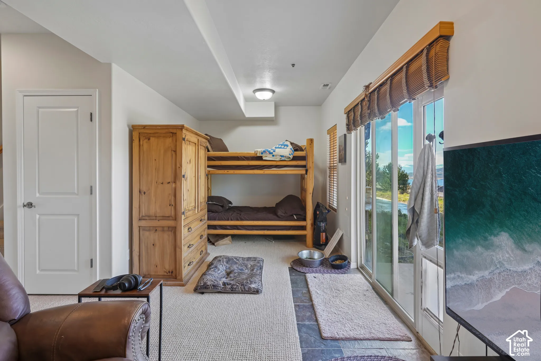 Sliding glass door with integrated pet door, textured carpet flooring, and stone-look tile flooring