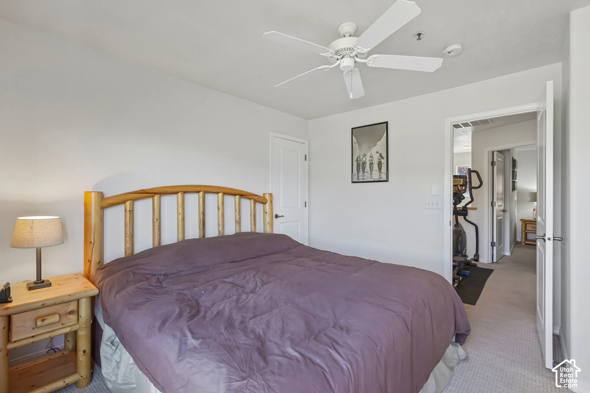 White walls, light-colored carpet flooring, ceiling fan, and white interior doors