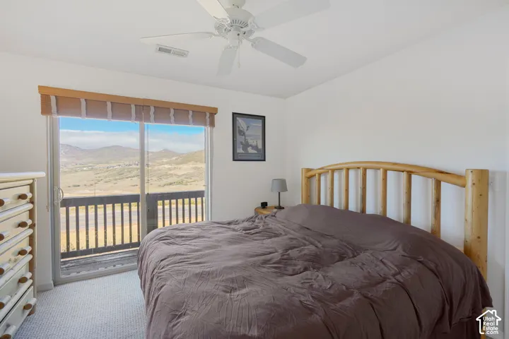 Sliding glass door opening to an exterior balcony with mountain scenery