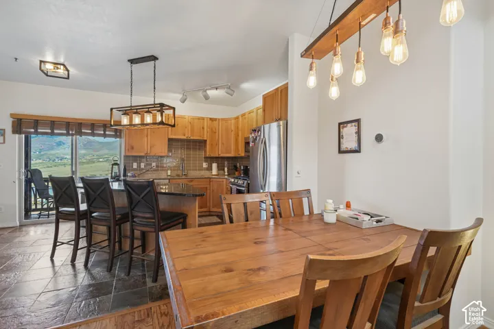 Kitchen with wood cabinetry, stainless steel appliances, and a tile backsplash