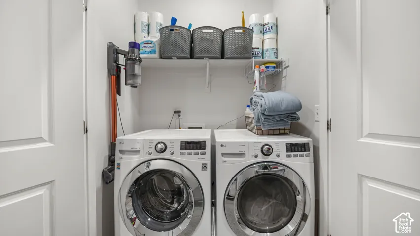 Laundry area with built-in shelving, white walls, and a front-loading washer and dryer