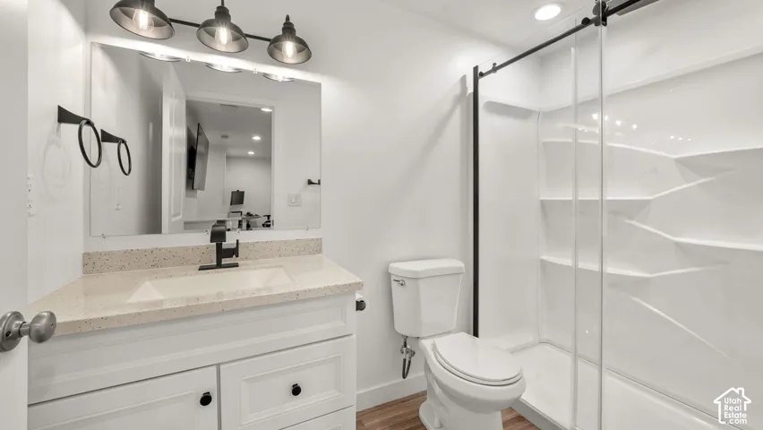 White vanity with an integrated sink, black faucet, and speckled countertop
