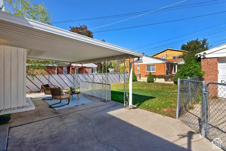 Covered patio area featuring a concrete surface and decorative metal railing