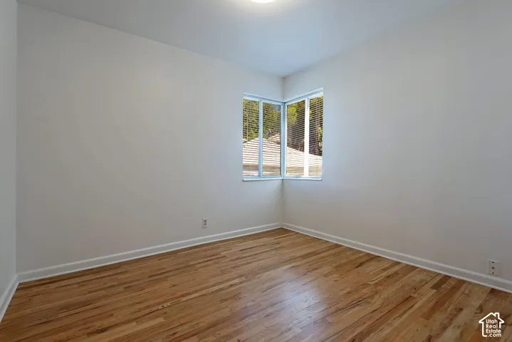 Hardwood flooring, corner windows, white walls