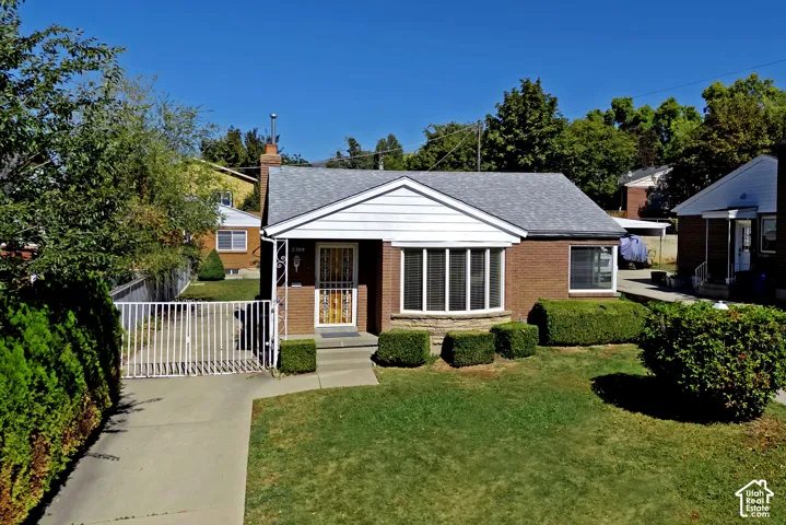 Red brick exterior with white siding accents and a gray shingle roof