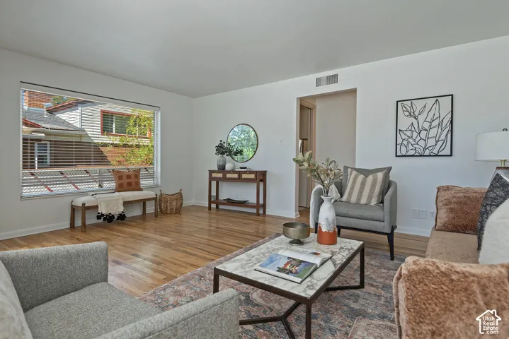 Hardwood flooring, expansive window, neutral wall tones, interior doorway