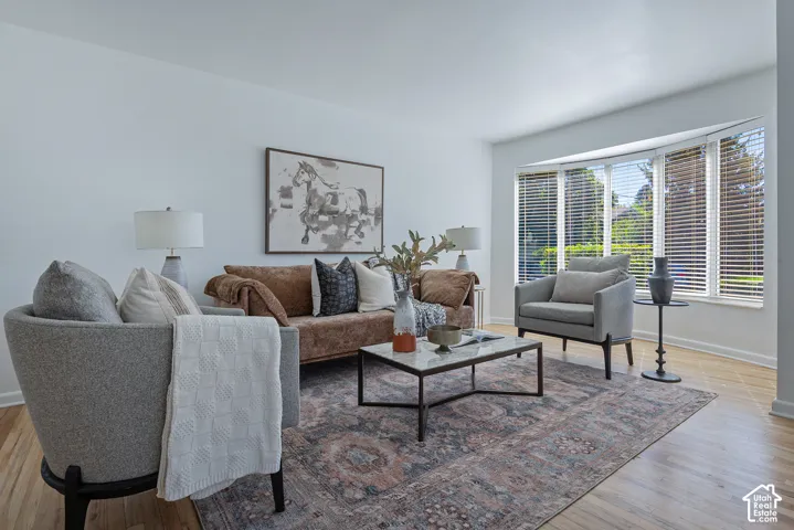 Bay window with multiple panels, wood flooring, and white walls