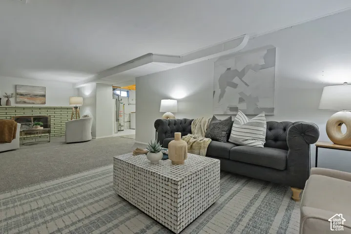 Neutral wall paint, carpet, and a fireplace with a light bricks