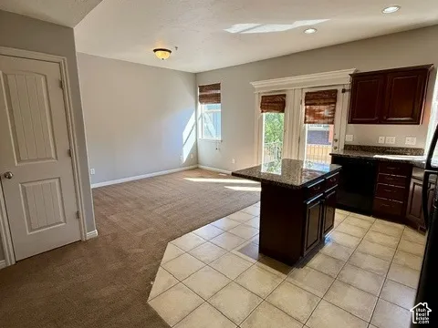 Kitchen area featuring a built-in island with countertop, dark wood-finish cabinetry, and tiled flooring