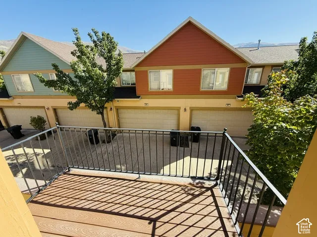 Balcony featuring wood-finish decking and dark metal railing