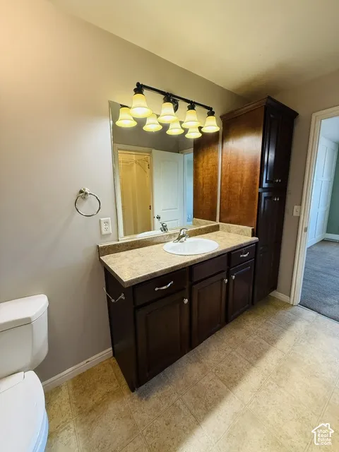 Dark wood-finish vanity with an integrated sink, laminate countertop, and overhead lighting fixture