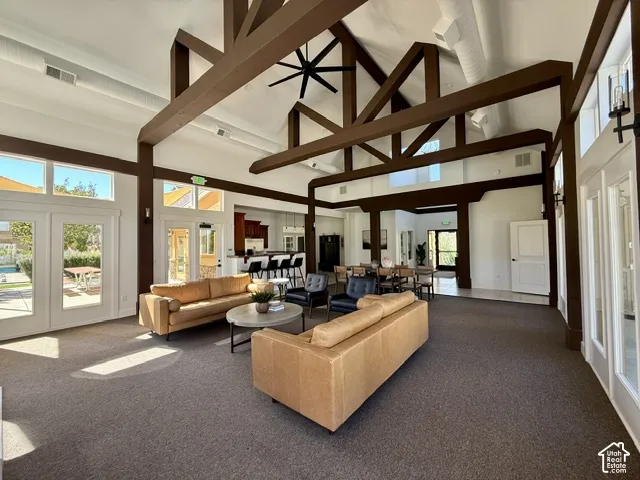 Vaulted ceiling with exposed beams, recessed lighting, and a ceiling fan
