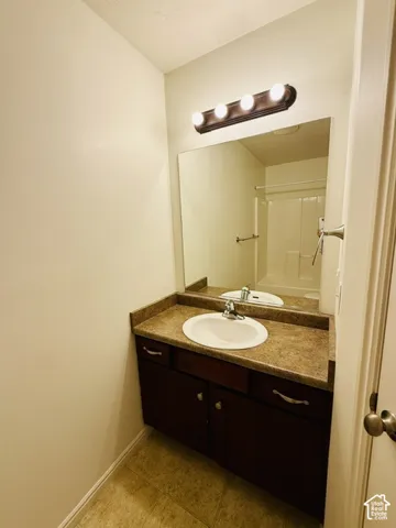 Vanity with a laminate countertop and an integrated sink, illuminated by a four-bulb fixture
