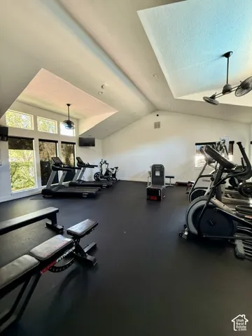 Fitness room with high vaulted ceilings and recessed lighting