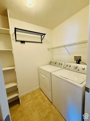 Built-in shelving, wall-mounted drying rack, utility shelf, and neutral tile flooring