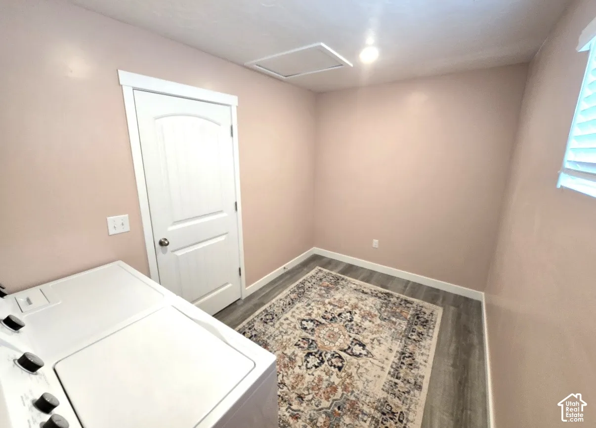 Wood-finish flooring, white window blinds, recessed ceiling lighting, and a white interior door with a silver-tone doorknob