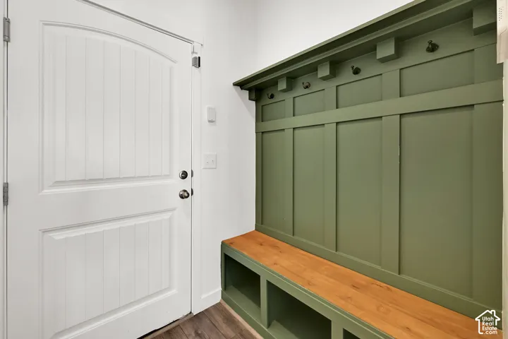 Built-in hall tree with a wood-finish bench, integrated storage cubbies, and coat hooks