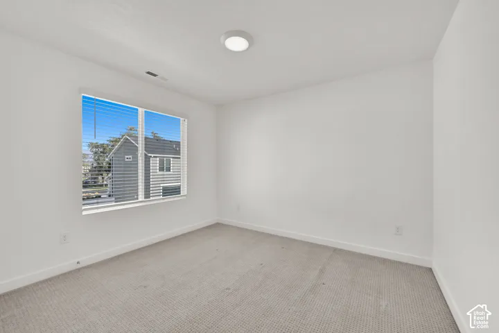 Recessed lighting, neutral wall paint, carpeted flooring, and a window with blinds