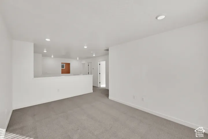 Recessed lighting, wall-to-wall carpeting, and a half-wall partition