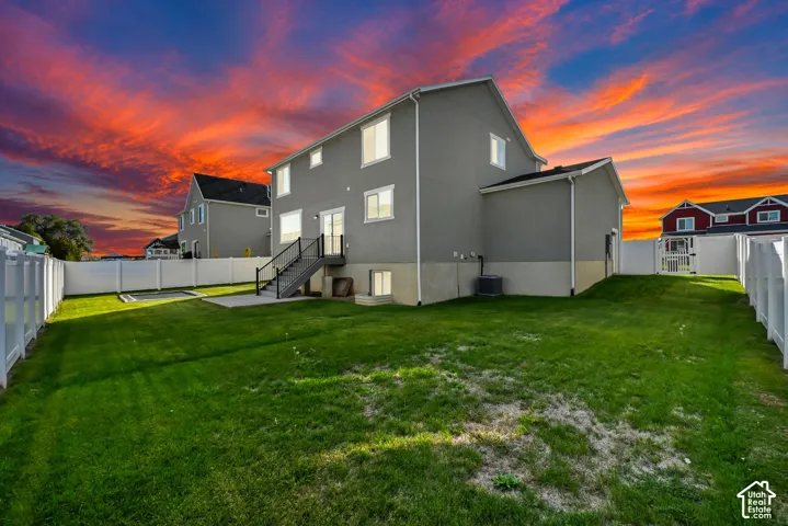 Expansive backyard featuring a manicured lawn, a concrete patio, and a privacy fence