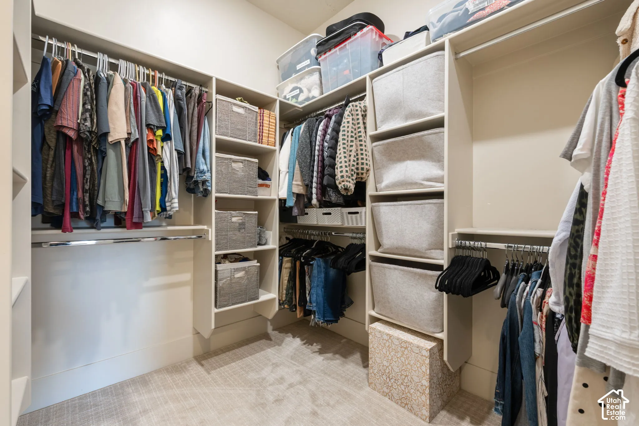 Walk-in closet featuring extensive built-in shelving, multiple hanging rods, and integrated storage compartments