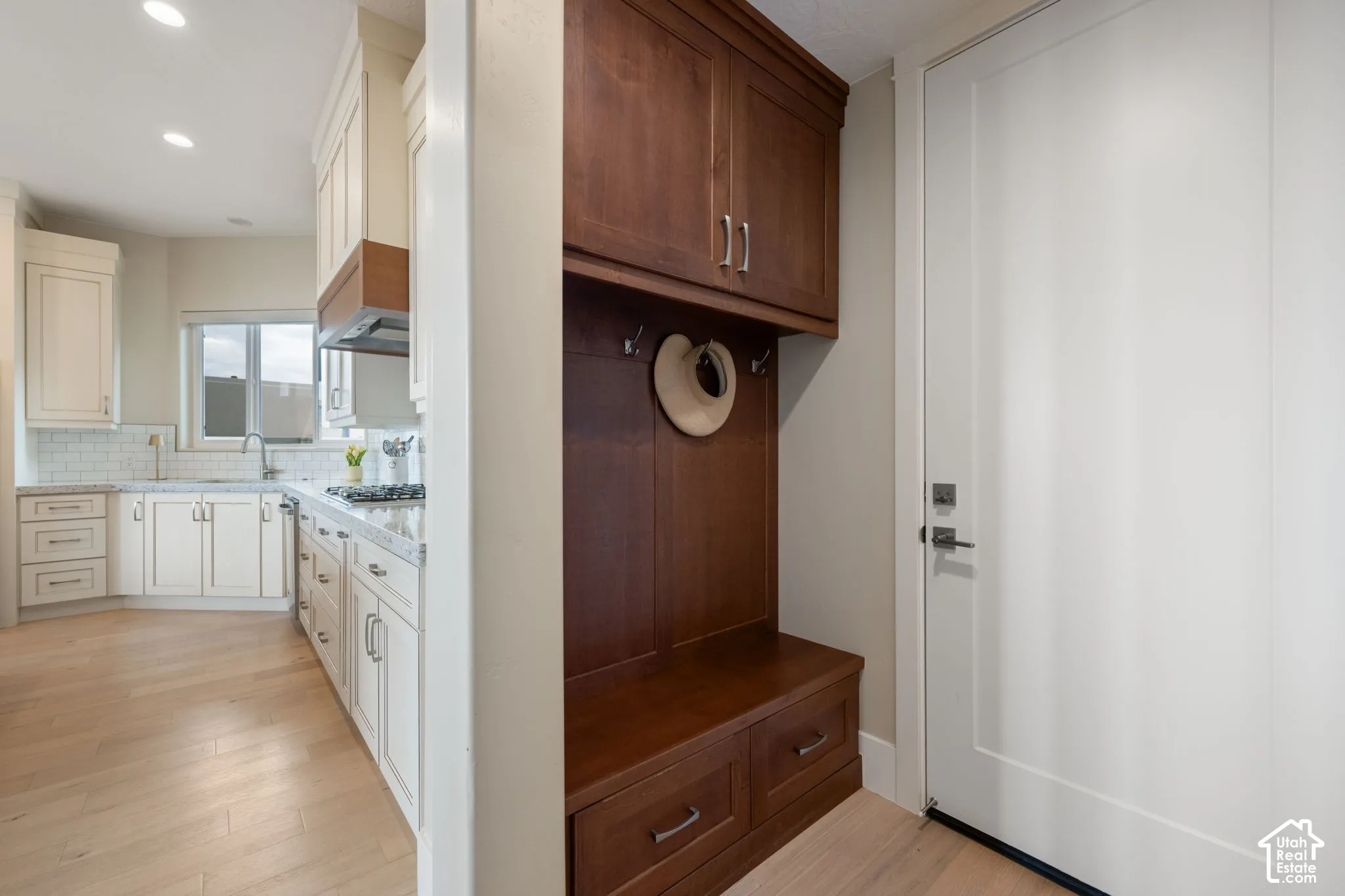 Built-in mudroom storage with bench seating and overhead cabinetry