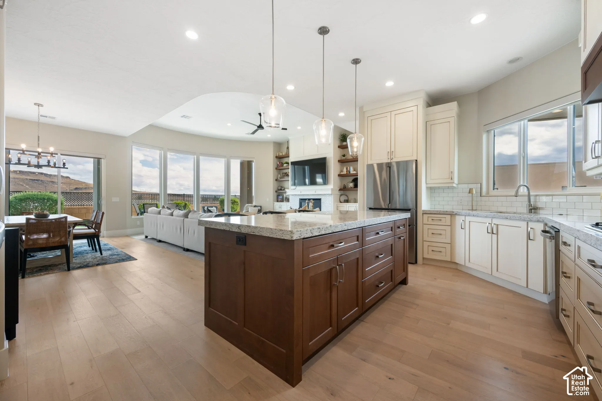 Gourmet kitchen with a large island, wood-finish flooring, and white cabinetry